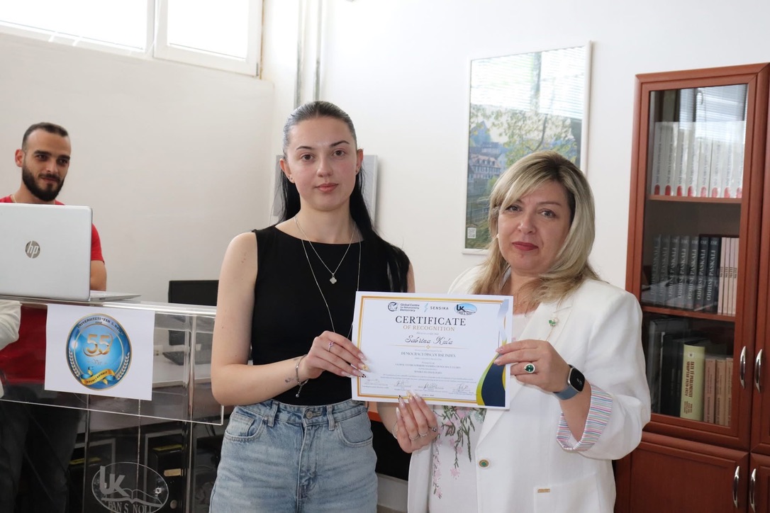 A student receiving a Certificate of Recognition for her work on the Democracy Discourse Index in Albania