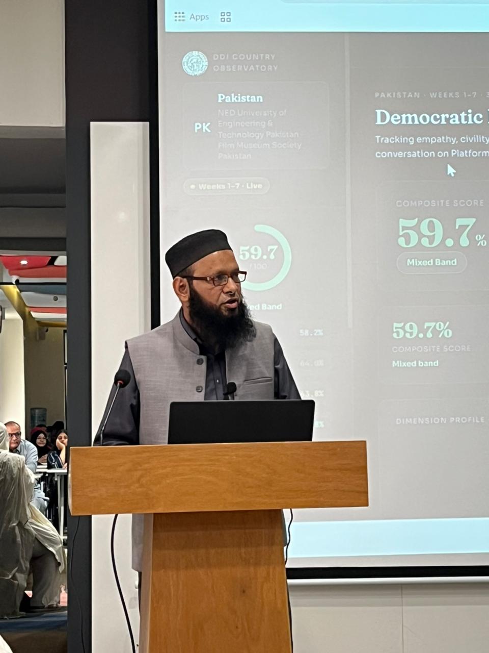 A speaker presents the Democracy Discourse Index Pakistan observatory, showing a 59.7% composite score